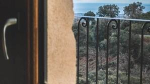 A window with a view of a forested landscape and a body of water. - Eco-gite Près de la Mer. 18 Couchages (Chiatra)