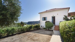 A white building with a red-tiled roof, a small porch, and a gravel driveway. - Villa Aqua Maris by Villa Plus (Rhodes)