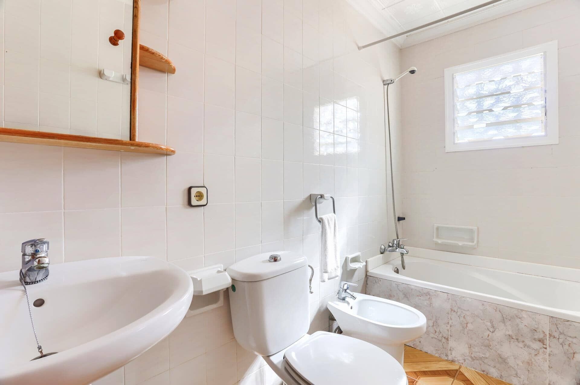 Une salle de bain comprenant des toilettes, un bidet, un lavabo et une baignoire.