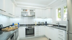 A modern kitchen with white cabinetry, a stainless steel range, and a built-in oven. - Villa Ariet by Villa Plus (Felanitx)