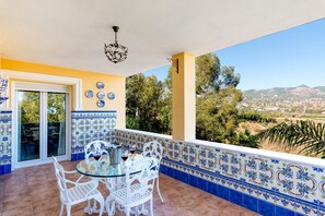 Relax on the patio with a clear view of the surrounding hills, surrounded by a glass table and comfortable chairs.