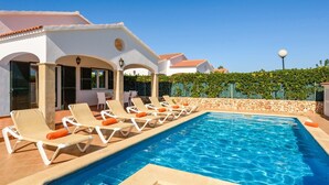 A swimming pool with lounge chairs and a covered patio area. - Villa Angelas by Villa Plus (Cap d'Artrutx)
