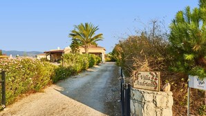 A gravel path leading to a villa with a sign that reads "Villa Andriana." - Villa Andriana by Villa Plus (Latchi)