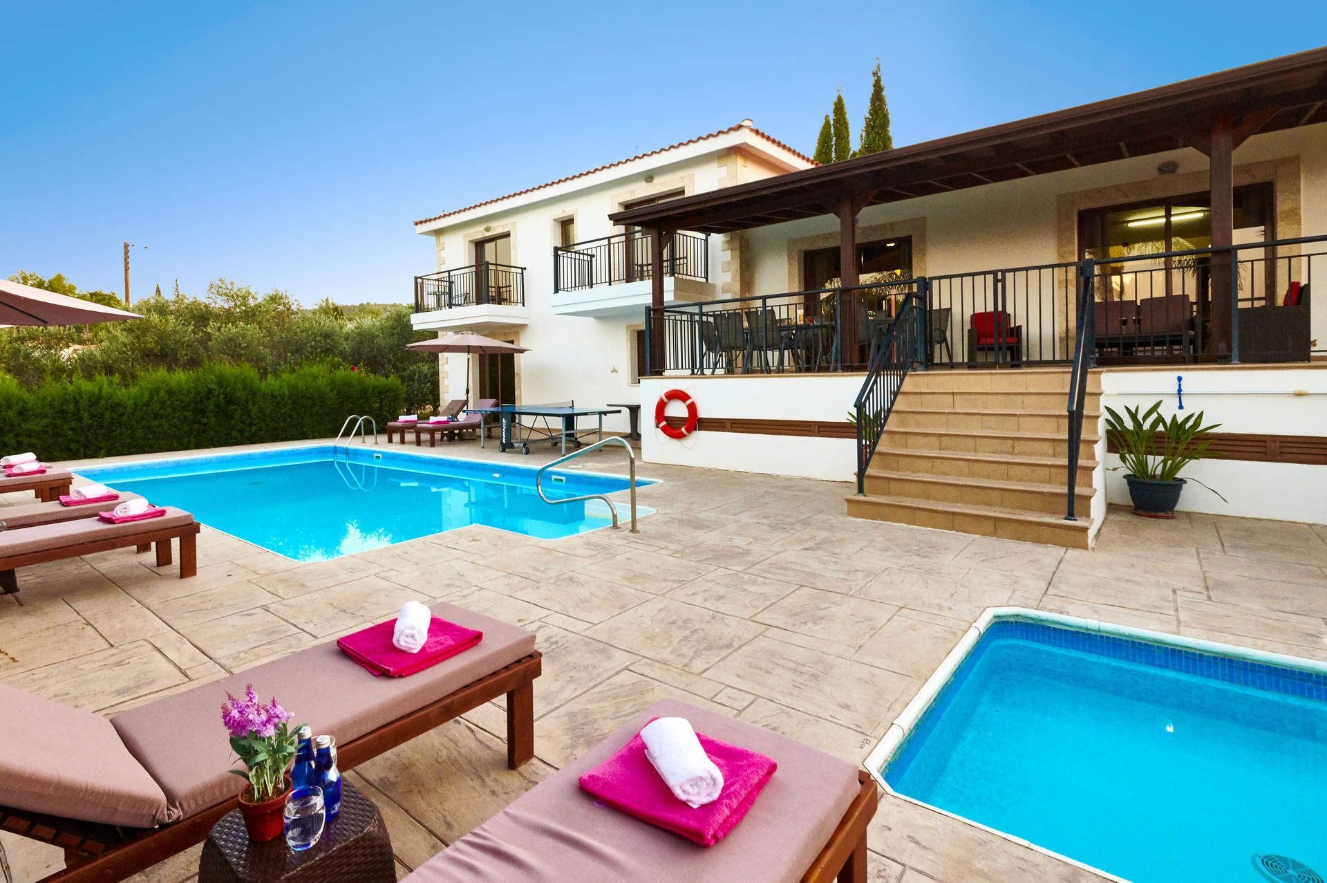 A swimming pool area with lounge chairs and a lifebuoy.