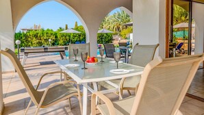 Une terrasse extérieure équipée d’une table de billard, de chaises et d’une table pour les repas.