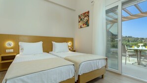 Habitació d'hotel amb dos llits, un balcó amb taula i cadires, i un quadre a la paret.