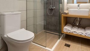 A modern bathroom with a glass-enclosed shower, a toilet, and a vanity with towels. - Villa Vilenia Horizon by Villa Plus (Katastari)