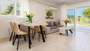 Una sala de estar moderna con comedor, sofá y una mesa con sillas.