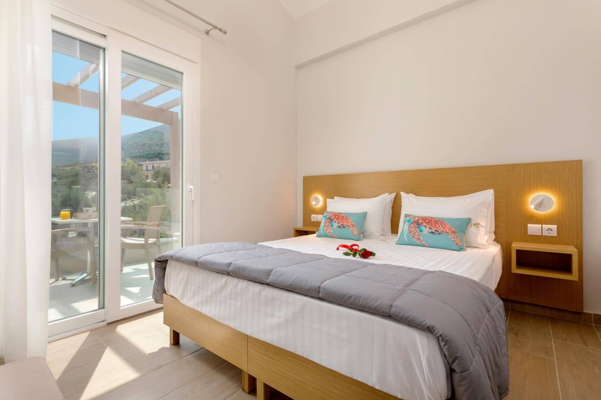 A bedroom with a bed, a nightstand, a window with a view, and a sliding door.