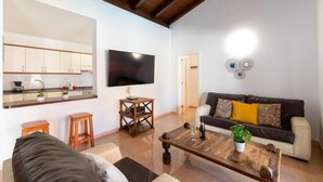 A living room with a sofa, coffee table, and a television.