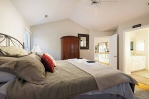 A bedroom with a bed, a wardrobe, a mirror, and a door leading to a bathroom. - Sound Views, Pool, Hot Tub, Game Room, Club Access (Corolla)