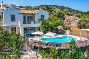 A modern villa with a swimming pool, stone walls, and a balcony overlooking the landscape. - Villa Zogianna by Villa Plus (Episkopos)