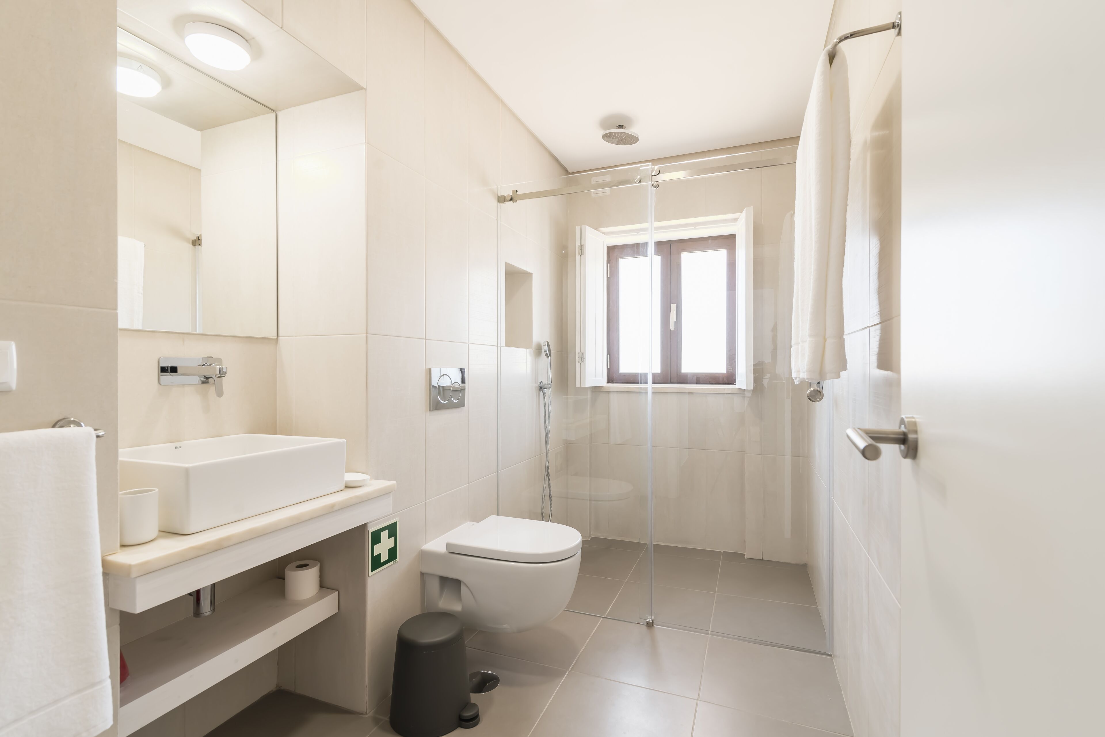 A modern bathroom with a sink, toilet, and shower.