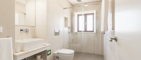 A modern bathroom with a sink, toilet, and shower.