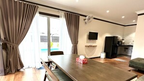 Een moderne keuken met een flatscreen televisie, een koelkast en een koffieapparaat.