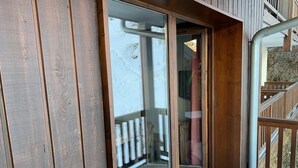 Ein Holzfassade mit einer Schiebetür, die auf einen Balkon führt.