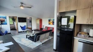 Una cocina moderna con refrigerador, estufa y comedor.