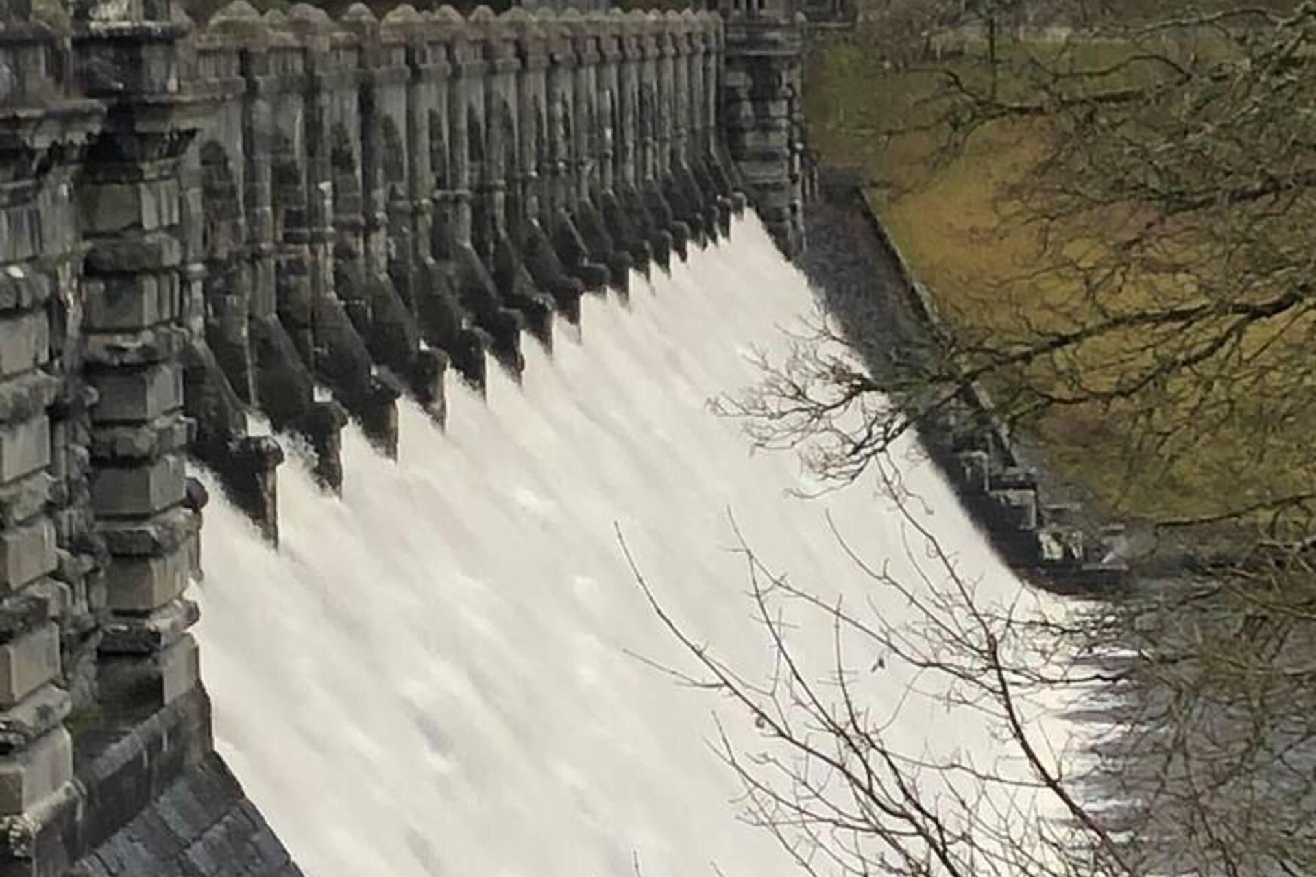 A large dam with water flowing over it.