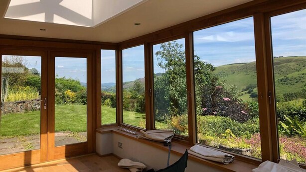 A room with large windows offering a view of a green landscape. - 3-bed Cottage Near Lake Vyrnwy, Garden & Petsok (Oswestry)
