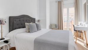 A hotel room with a large bed, a desk, and a chair. - Madrid Hotel (Torrevieja)