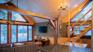 A cozy cabin interior with a wooden dining table, a built-in bench, and a staircase. - Mercer, WI Beautiful Flambeau Flowage Cabin (Butternut)