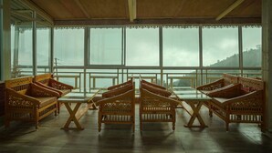 Una habitación con muebles de madera y ventanas amplias.