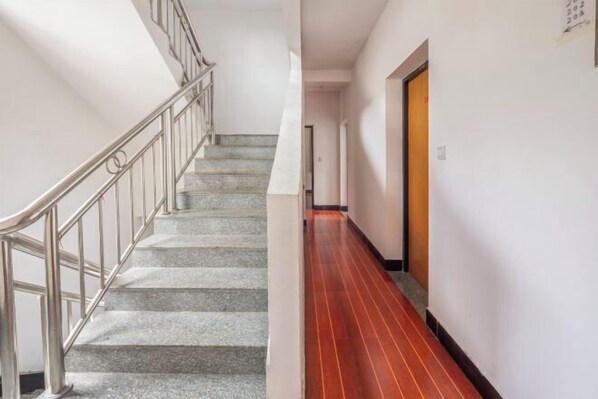 A staircase with metal railings leading to a landing. - Qingyuan Farm Stay (Wuyuan)