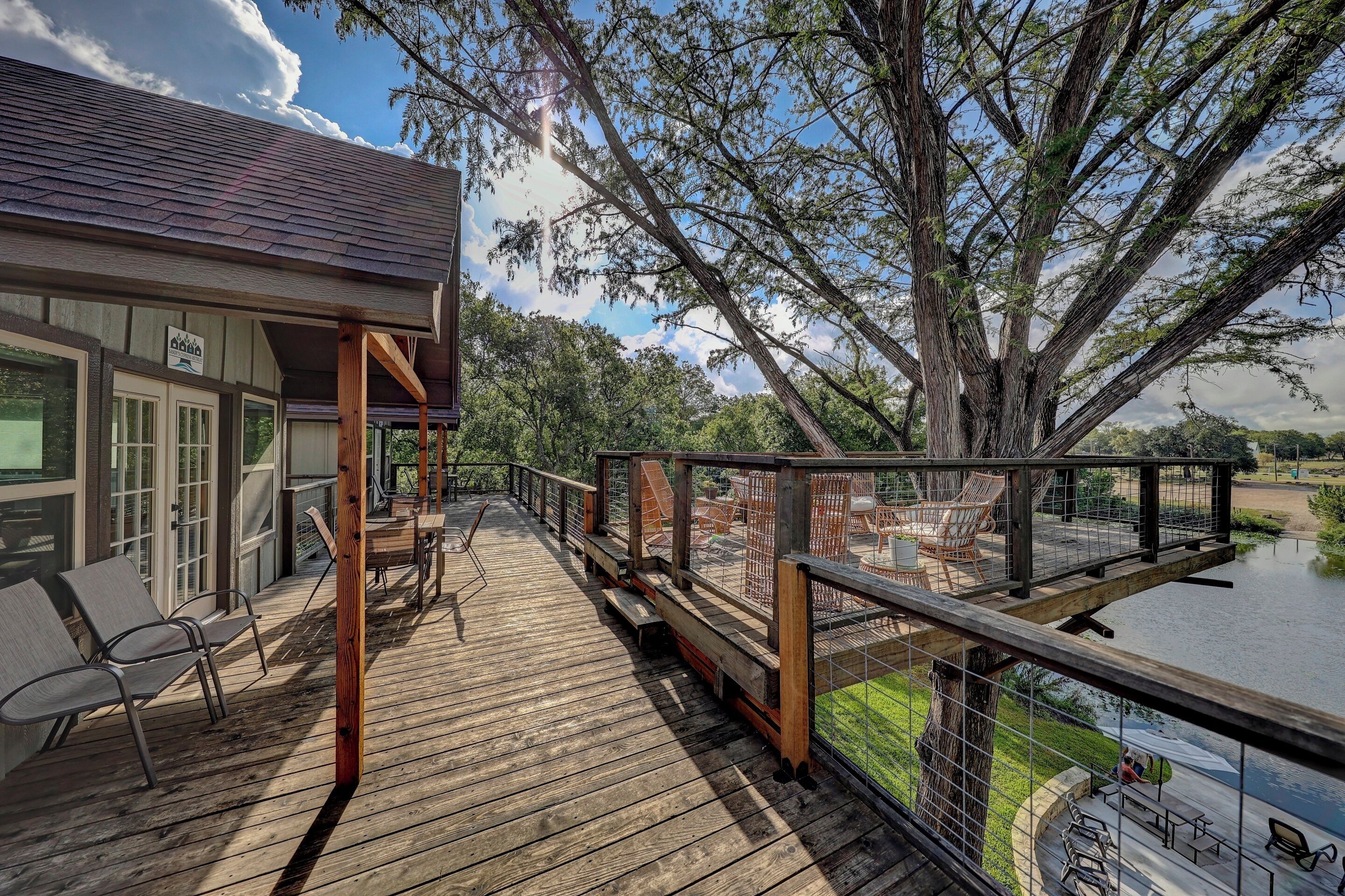 A wooden deck with outdoor seating and a view of a lake.
