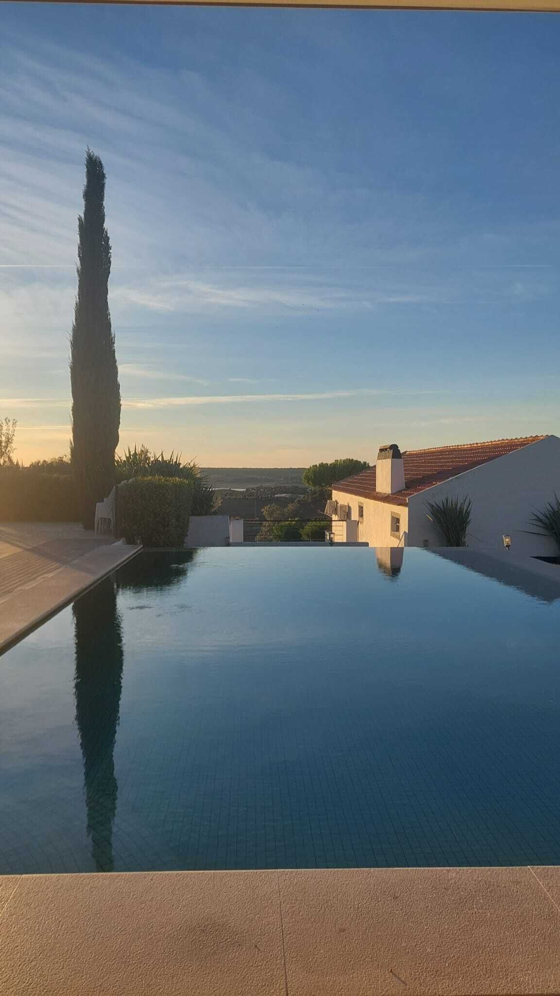 Une piscine offrant une vue dégagée sur un bâtiment et un paysage en arrière-plan.