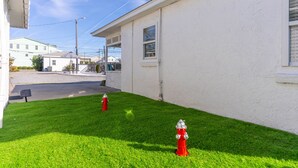 A residential area with two red fire hydrants on a well-maintained lawn. - Hanby Hideaway~ Cottages @ Kure ~ Beach, Fishing, Pool, Walk to Pier (Kure Beach)