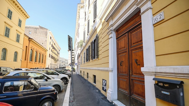 Une rue étroite bordée de voitures garées et de bâtiments historiques.