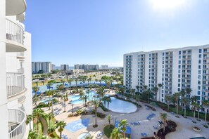 Ett hotell med en pool på taket, flera balkonger och utsikt över den omgivande stadsbilden.