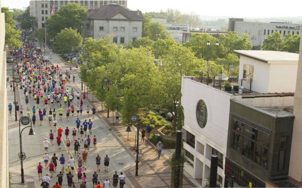 A large group of people participating in a marathon on a city street.