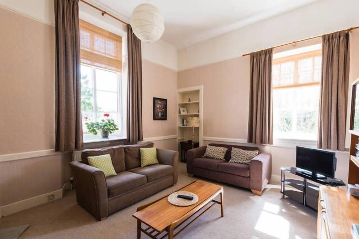 A living room with two sofas, a coffee table, a TV, and a bookshelf.