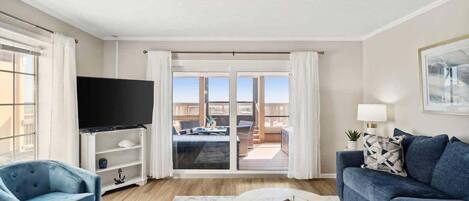Una sala de estar con televisor, sofá y mesa de centro.