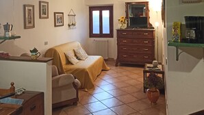 Une pièce confortable avec un lit, une commode, une chaise et une petite table sur laquelle est posée une plante.