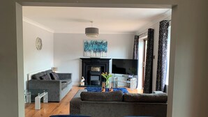 Uma sala de estar moderna com lareira, televisão de tela plana e um conjunto de sofás.