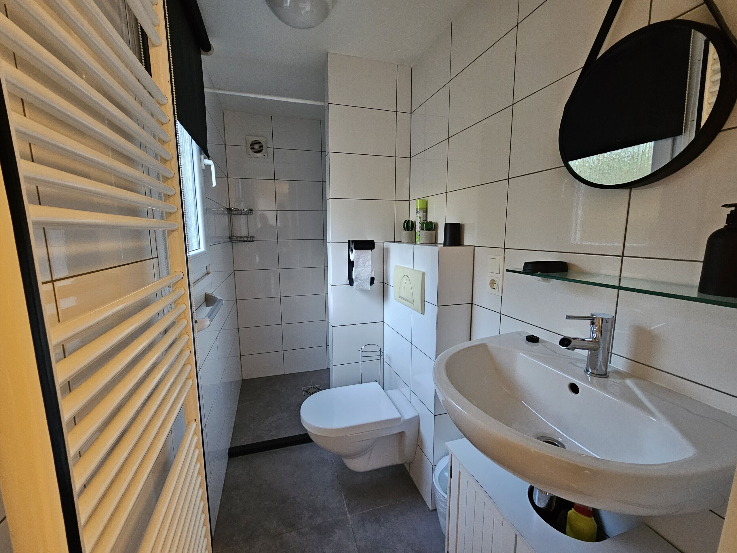 A modern bathroom with a toilet, sink, and shower.