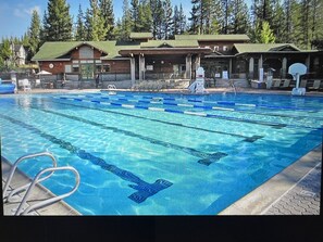 Relax by the pool surrounded by a serene forest setting, perfect for a leisurely swim or a moment of tranquility.