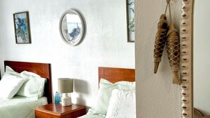 Ein Hotelzimmer mit zwei Betten, einem runden Spiegel und einem Holzkopfende.