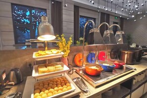 A buffet setup with various food items and cooking utensils. - Homeinn Plus Hotel (Suzhou Fenhu Luxin Avenue) (Suzhou)