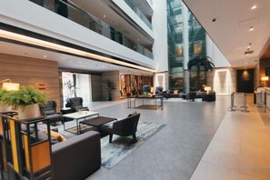A spacious lobby with seating areas, a reception desk, and a large glass wall. - Homeinn Plus Hotel (Suzhou Fenhu Luxin Avenue) (Suzhou)