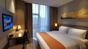 A hotel room with a bed, a desk, a television, and a painting on the wall. - Homeinn Plus Hotel (Suzhou Fenhu Luxin Avenue) (Suzhou)