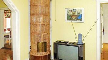 A room with a wooden pillar, a television, and a painting on the wall.