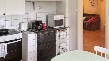 Una cocina compacta con estufa, microondas y horno pequeño.