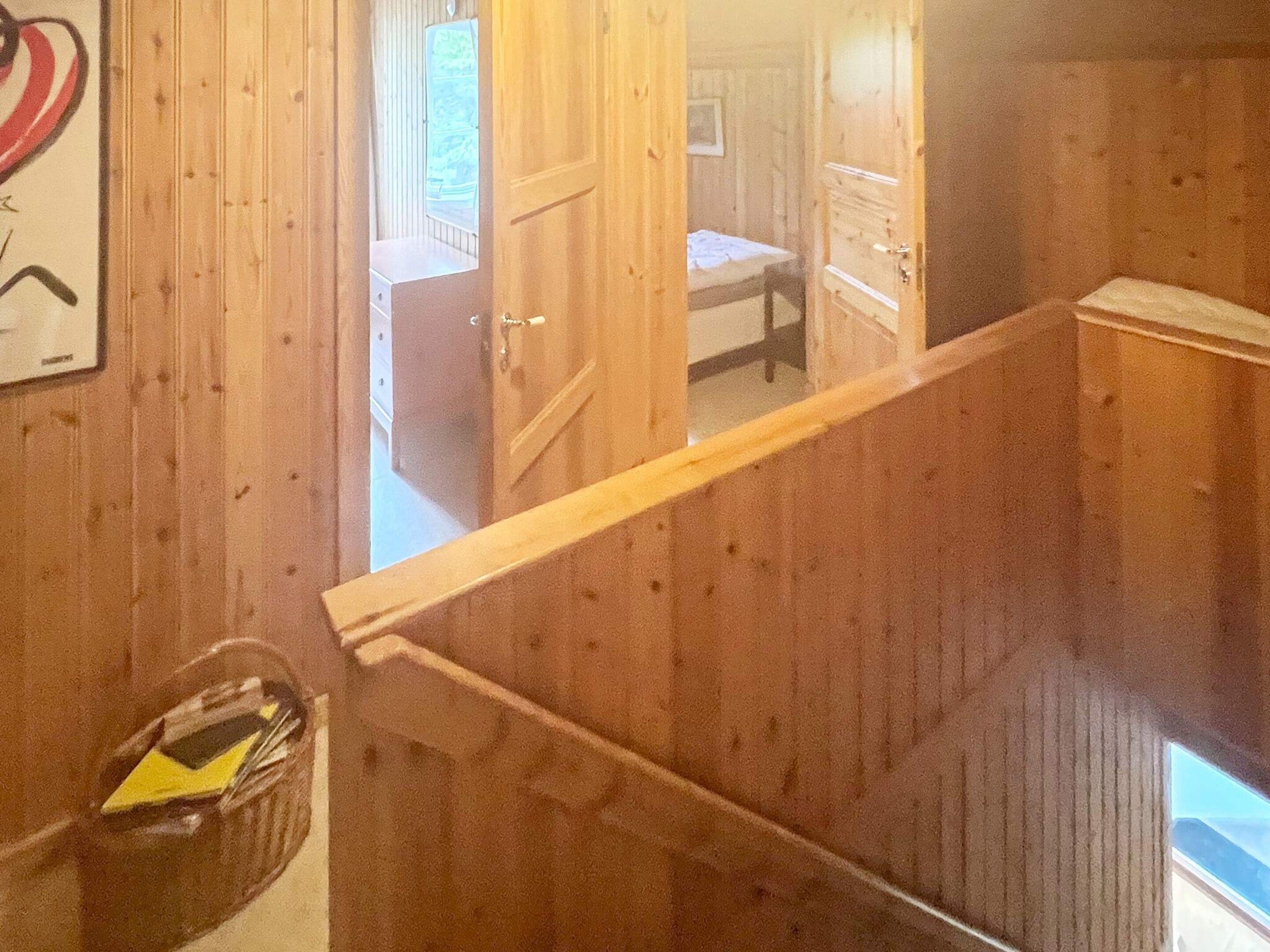 Un interior de madera con una escalera que conduce a un dormitorio.