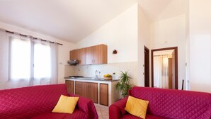 A compact living space with two red sofas and a kitchen area. - A corner of paradise waiting only for you! (JOPPOLO)