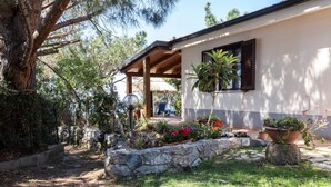 A house with a covered porch, stone retaining walls, and potted plants. - A corner of paradise waiting only for you! (JOPPOLO)