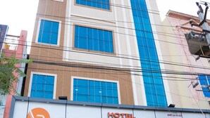 Een hotel met een opvallend 'VR GRAND INN' bord, een moderne gevel met grote ramen en een duidelijke ingang.
