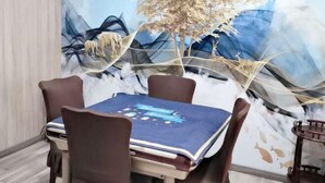 Un comedor con una mesa cubierta por un mantel azul, rodeado de cuatro sillas marrones.